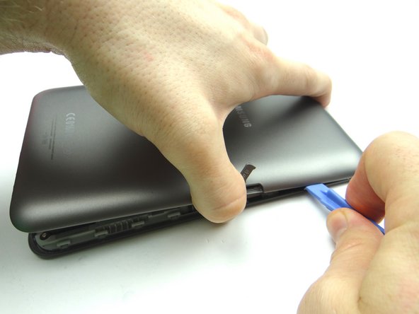 Picture 2: Sweep blue pry tool under SD slot to free the clips.