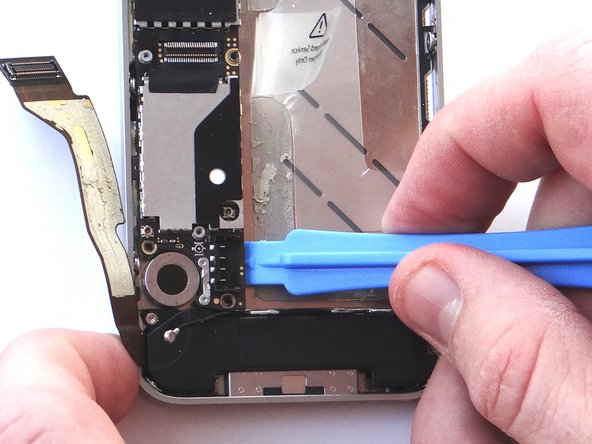 Picture 1: Using the blue pry tool, carefully lift the logic board just high enough to pinch it with your left thumb and index finger.