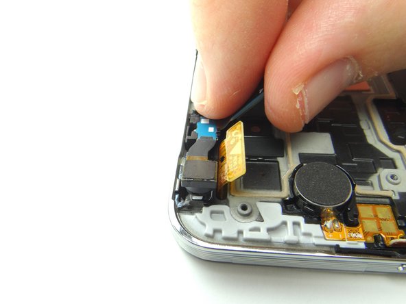 Use curved tip tweezers to remove the metal bracket covering the front-facing camera and proximity sensor assembly.