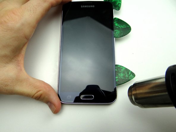 Picture 2: Use a third guitar pick to continue cutting through adhesive along the right side.  Apply heat to the lower-right corner.