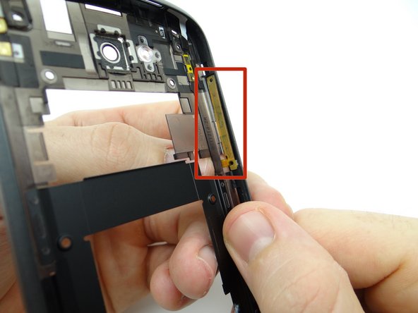 Use the flat end of the spudger to push the volume rocker and cable free.