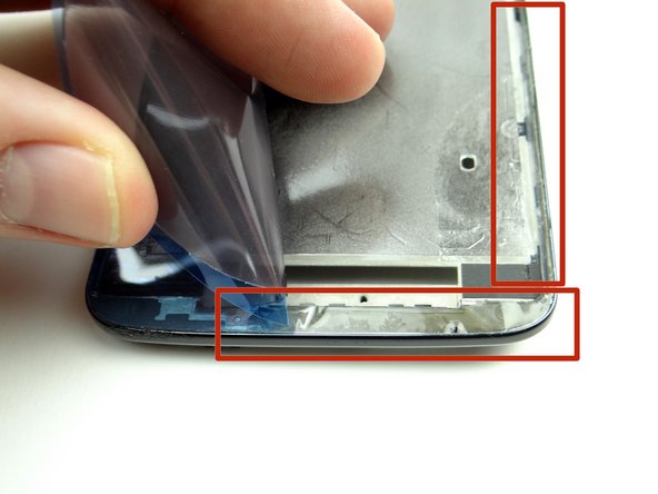 Picture 2: Peel the backing off the bottom half of the adhesive and lay it along the bottom half of the mid-frame.  Use curved-tip tweezers to push the adhesive into place.