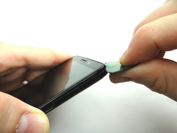 Picture 1: Insert guitar pick between the front panel and battery cover in the upper-right corner.  Sweep down from the corner to SIM card tray opening.