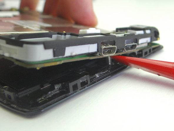 Picture 2: Wedge the spudger just right of the standoff. Twist clockwise slightly.
