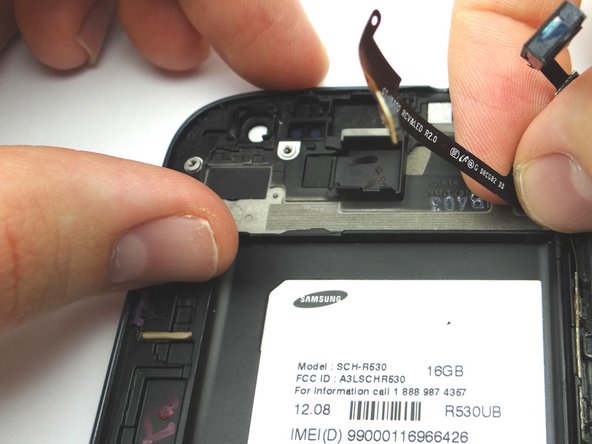 Working from right to left, secure the ribbon cable to the phone.