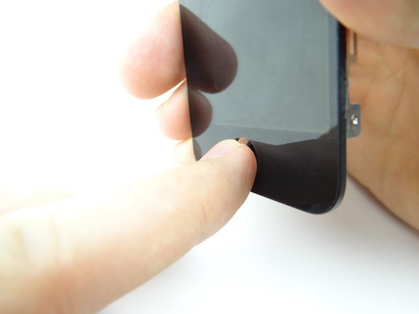 The home button is held in place with mild adhesive.  Use your thumb to push the home button away from the front panel.
