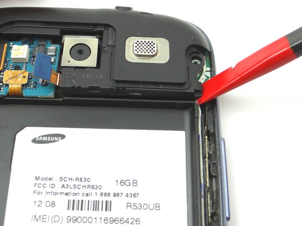 Picture 2: Place the flat tip of the Black Spudger in the bottom right corner of the headphone jack/speaker assembly and gently pry up to release it from the phone.