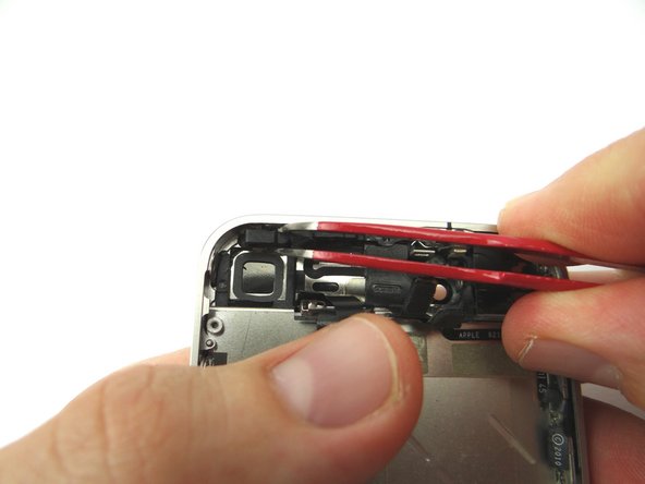 Picture 2: Using Curved Tip Tweezers, move the power button out of its position, be extremely careful with the ribbon cable that is still attached.