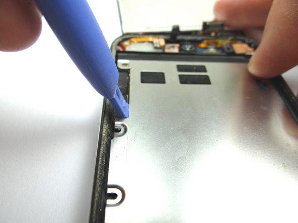 Picture 3: Use the Blue Pry Tool along the left edge to continue prying up the metal plate.