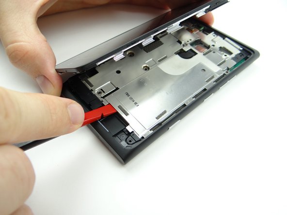 The battery is adhered to the underside of the mid-plate and should come up with it (as shown in the next step).