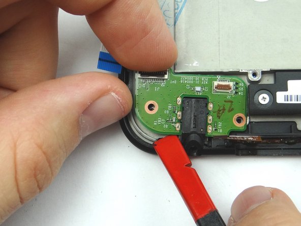 Use flat end of spudger and your fingers to pry up headphone jack board.