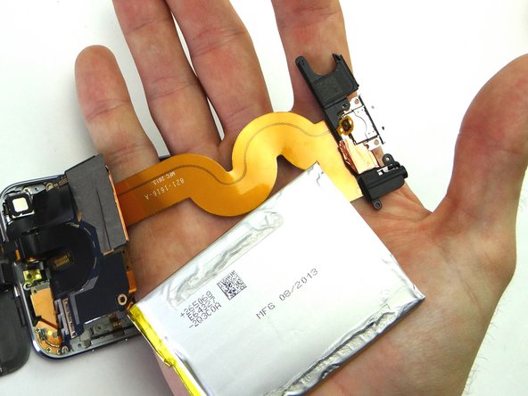 Picture 1: With the battery and charging port assembly in hand, gently flip it over.