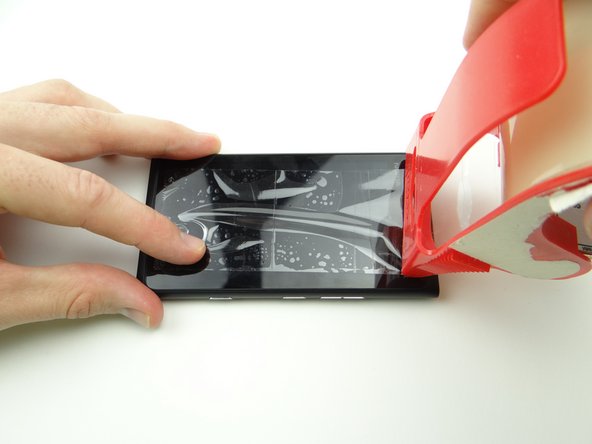 Put packing tape over the screen to hold the broken pieces of glass together.  Smooth out the bubbles.