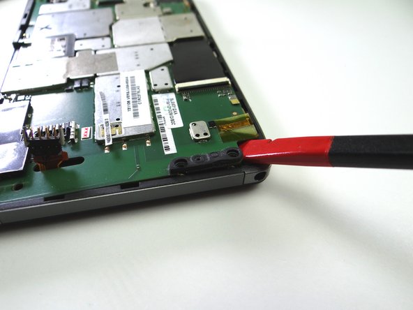 Picture 2: Use the flat end of the spudger to pry up the lower-left corner of the logic board.