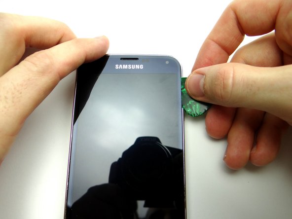 Pictures 2 &amp; 3: Insert a guitar pick in the corner and run up and down two inches, cutting through the adhesive.