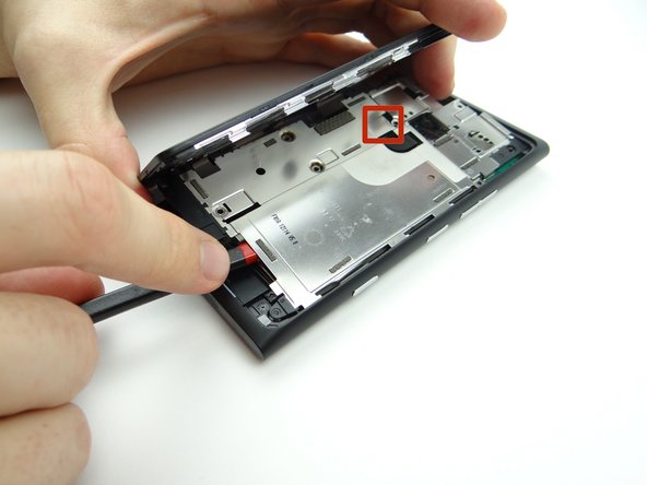 Picture 1: Wedge the flat end of the spudger under the mid-plate exactly where shown.
