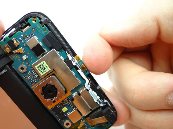 Picture 1: Wedge the tip of the iSesamo directly under the power button contact.  Be careful not to put pressure on the seating tabs (red squares).