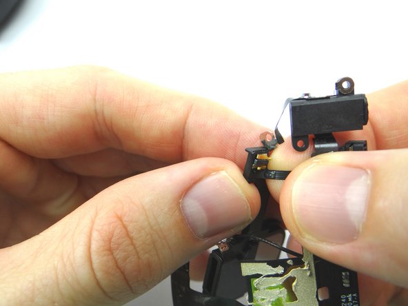 Picture 1: Use your fingers to gently pry the charging port ribbon cable away from the speaker assembly.