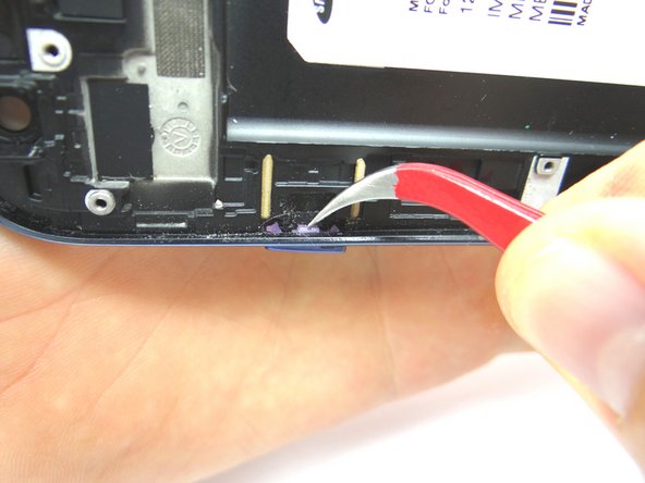 Use the Curved Tip Tweezers to remove the power button by pushing it out of the frame. Place power button into COMPARTMENT G.