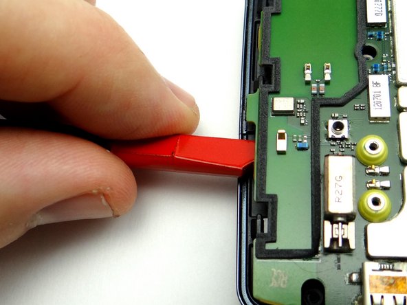 Wedge under the logic board until you reach the notch in the spudger (as shown in Picture 3).  Lift slightly to free the bottom of the board from the adhesive holding it down.