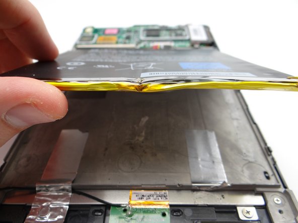 Lift the battery up from the bottom to free it from the adhesive.