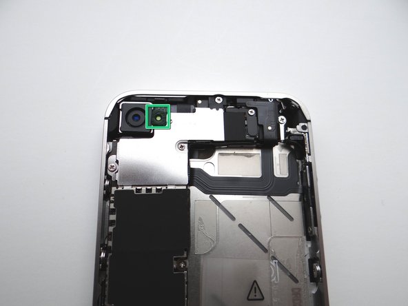 From COMPARTMENT B, if present, replace the outer plastic ring located on top of the rear camera's flash.