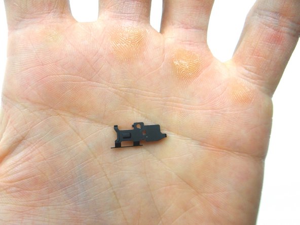 With the top of the phone facing your body, grab the metal shield with the Curved Tip Tweezers.  Peel up the clip to your right first, then the bottom left and finally the top left. Place clip into SLOT 4.