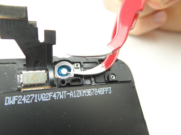 Use a single prong of the curved-tip tweezers to wedge under the front-facing camera frame.  Cover the frame with your left hand to stop it from launching into the air as you lift the frame with the tweezers.