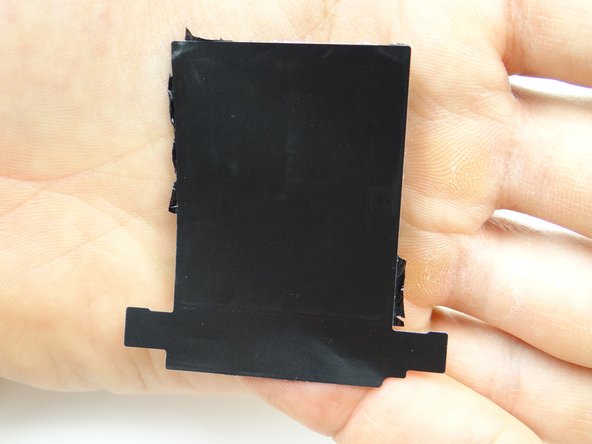 Place it on the inside of the battery cover in ZONE I, sticky side down.