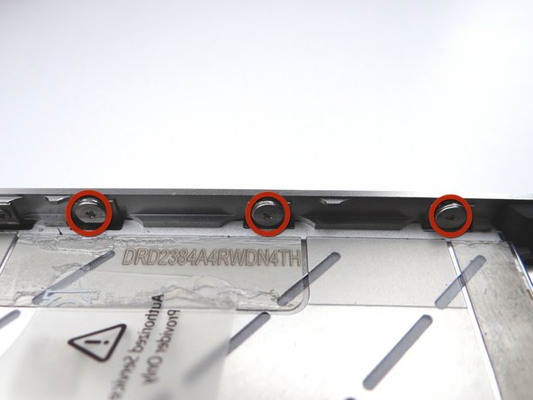 Picture 3: Loosen the three large-head Phillips screws along the right side of the iPhone about one half turn, taking care not to remove these screws.