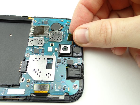 The earpiece speaker is wedged tightly into its slot: use your fingers to carefully peel it up just enough to wedge the spudger underneath.