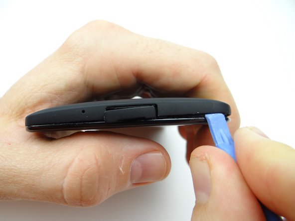 Picture 1: Sweep along the bottom edge from left to right releasing clips holding the battery cover down.