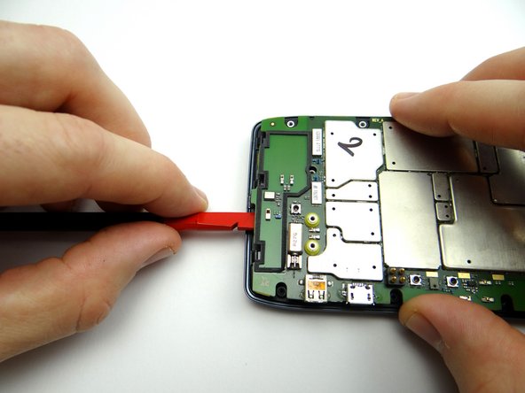 Use the flat end of the spudger to pry up the bottom of the logic board slightly.