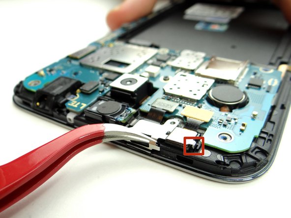 Close tweezers and unhook the tab in the red square first.  Continue lifting shield away from phone.