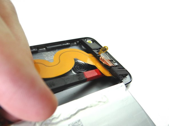 Picture 1: Push the flat end of the spudger under the charging port ribbon cable and pry up until you're able to grab the assembly with your fingers.