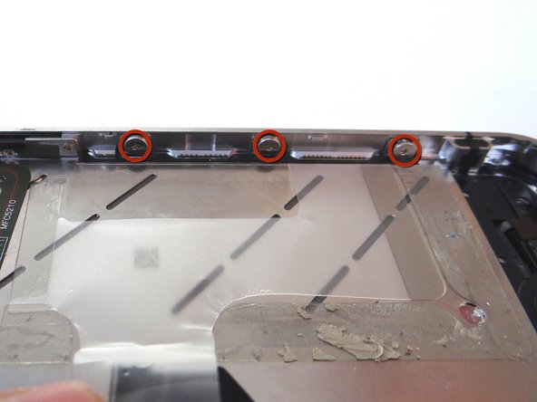 Picture 3: Loosen the three large-head Phillips screws along the right side of the iPhone about one half turn, taking care not to remove these screws.