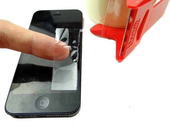Cut a thin strip of packing tape and fold it over the lower-right corner of the iPhone.