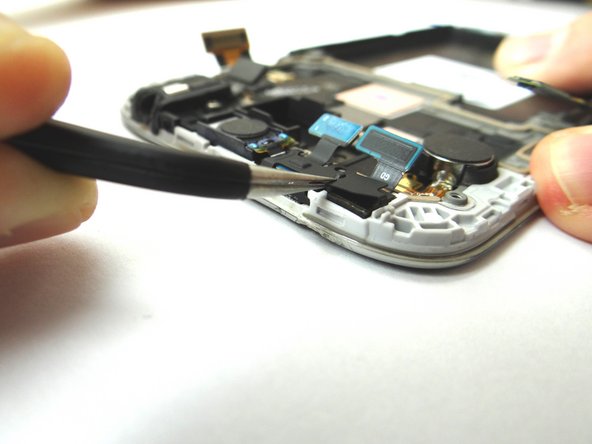 With the top of the phone facing your body, grab the metal shield with the Curved Tip Tweezers.  Peel up the clip to your right first, then the bottom left and finally the top left. Place clip into SLOT 4.