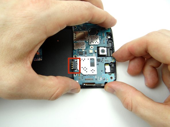 Picture 1: Wedge flat end of the spudger under the corner of the logic board.  Slowly twist the spudger to free the adhesive under the battery contact.