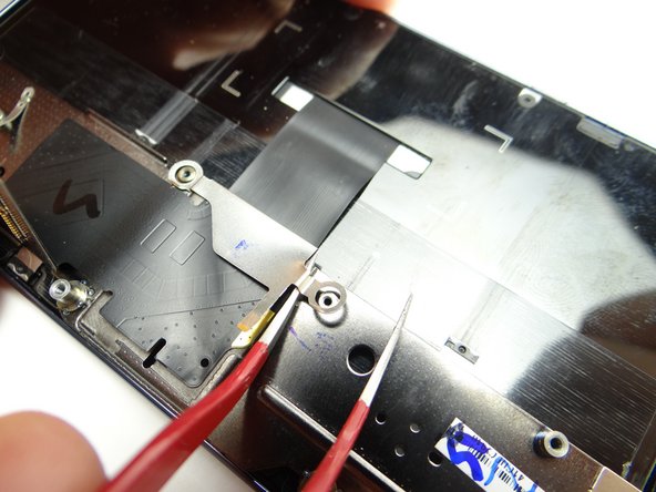 Use one prong of the tweezers to lift the bracket away from the phone.