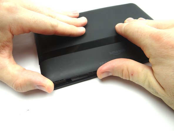 Work your way around the perimeter with your fingers.  Continue peeling the battery cover up until it's free.