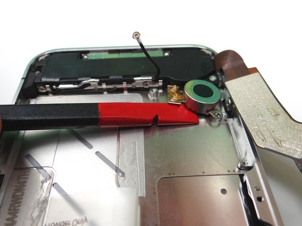 Picture 2: Wedge the flat end of the spudger (you may prefer to use the iSesamo) under the vibrator until it's free.  Place it in COMPARTMENT C.