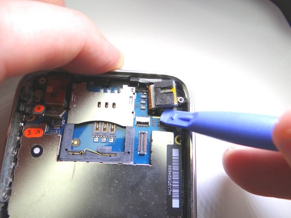 Pictures 1 &amp; 2: Use blue pry tool to lift the camera slightly out of its socket, as shown in Picture 2.