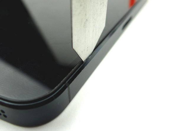 Picture 3: Slowly rotate the iSesamo in one hand while pinching the screen with your opposite hand.  Lift just enough to insert the blue pry tool in the lower-right corner.