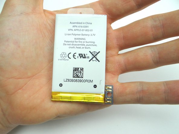 Place the battery in the rear case: seat the contact pad first, then continue seating the battery.