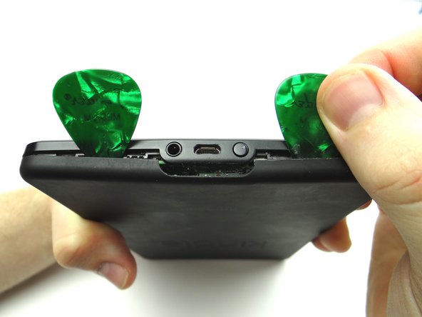 Picture 2: Pry the battery cover open just enough to insert a guitar pick right of the power button.