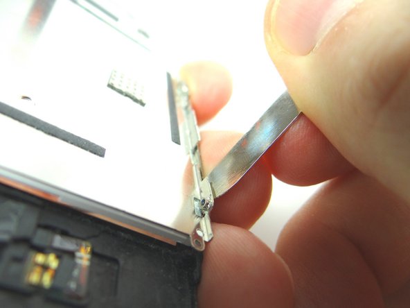 Wedge metal spudger between the back plate and side frame. Gently rotate the spudger to lift the LCD up from the glass.