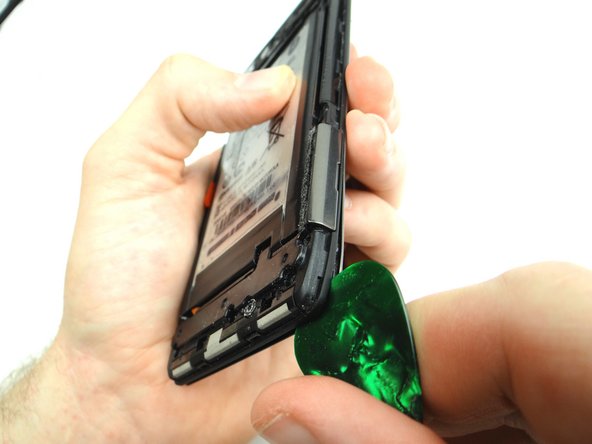 With the phone face down wedge the guitar pick between the display and mid-frame in the upper-right corner.  Run the guitar pick down the right side to release clips holding mid-frame to the display.