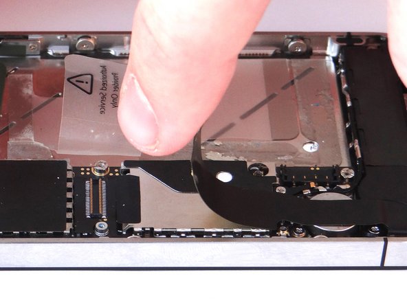 Picture 2: The charging port assembly cable is adhered to the logic board – gently peel it free from the logic board, working top to bottom until cable is free of logic board. Be cautious as this cable is very fragile.