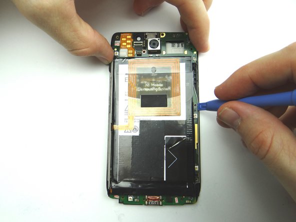 Picture 2: While holding up the top of the logic board with your fingers, pry up right side with the blue pry tool.